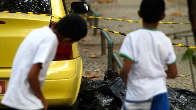 <br>Crianças observam o corpo de mulher que acabava de descer de um táxi e foi atingida por tiros durante o confronto entre a polícia carioca e bandidos
