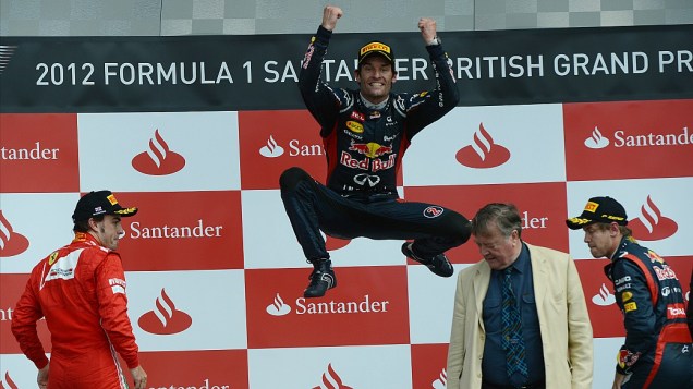 O vencedor do GP da Inglaterra de Formula 1, Mark Webber, celebra a vitória no pódio do circuito de Silverstone. Fernando Alonso, da Ferrari (esquerda) chegou em segundo e Sebastian Vettel, da RBR (direita) em terceiro