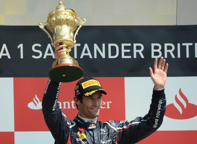 O australiano Mark Webber, da RBR, comemora a vitória erguendo o troféu do GP da Inglaterra