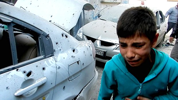 Criança chora em meio a tiroteio em Homs, na Síria