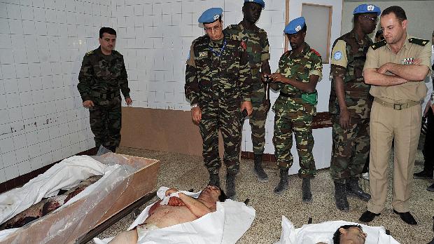 Integrantes da missão da ONU observam corpos de vítimas do conflito na Síria