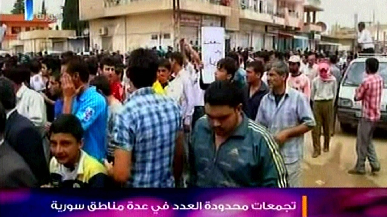 Televisão estatal da Síria mostra um protesto de sábado, em uma cidade não definida