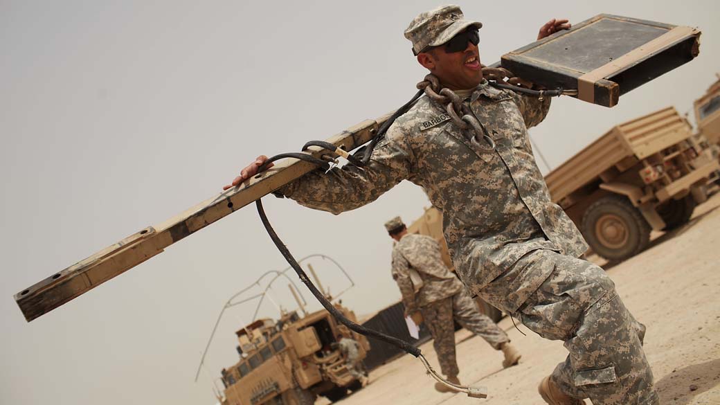 Em Iskandariya, Iraque, soldados americanos organizam veículos e armas militares para retornar aos Estados Unidos