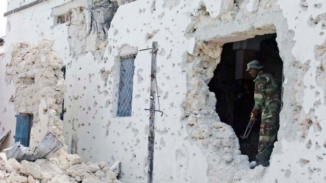 Na cidade de Mogadishu, Somália, soldado inspeciona casa destruída durante confronto entre militares do governo somali e rebeldes islâmicos