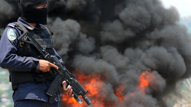Policial fica de guarda próximo a cerca de 400 kg de cocaína que são queimados em Tegucigalpa