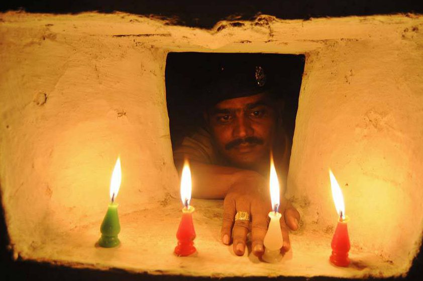 Soldado acende vela em comemoração ao festival Diwali, conhecido como festival das luzes, em Agartala, na Índia