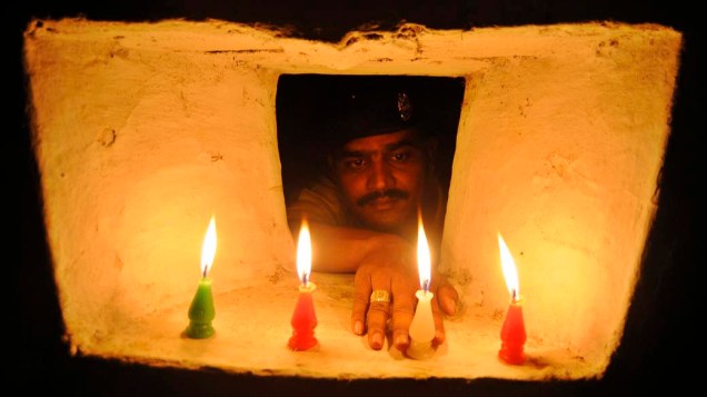 Soldado acende vela em comemoração ao festival Diwali, conhecido como festival das luzes, em Agartala, na Índia