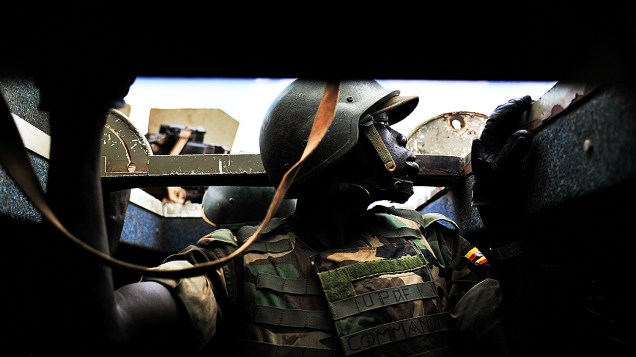 Soldado se protege em tanque após disparos de militantes do Al-Shabab contra o comboio de Uganda em via de Baidoa, na Somália