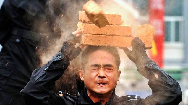 Policial quebra tijolo na cabeça em treinamento antiterrorismo no condado de Wengan, na China