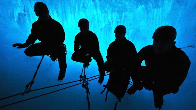 Soldados Ingleses escalam câmaras de gelo perto Rothera na Antártida