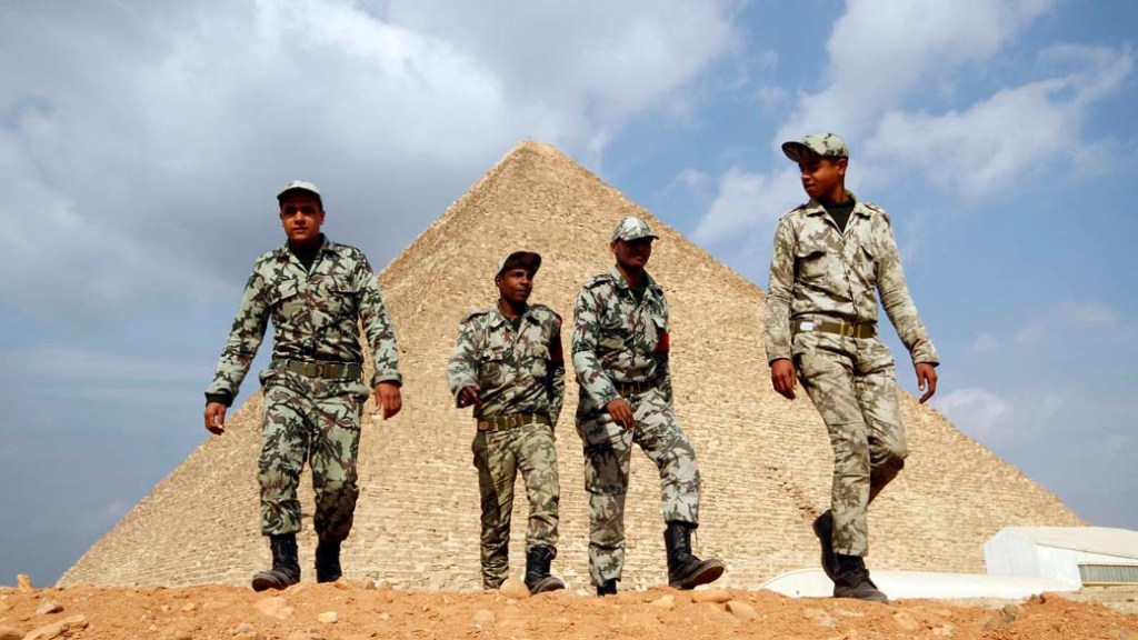 Soldados egípcios caminham perto das pirâmides de Gizé, Cairo. O local sofre com a falta de turistas desde o começo dos protestos no Egito
