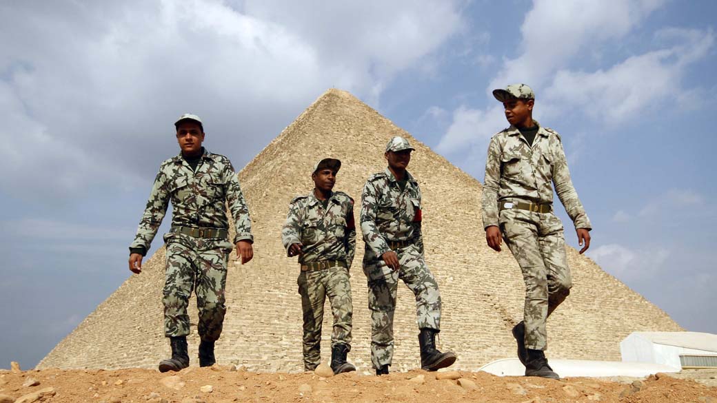 Soldados egípcios caminham perto das pirâmides de Gizé, Cairo. O local sofre com a falta de turistas desde o começo dos protestos no Egito