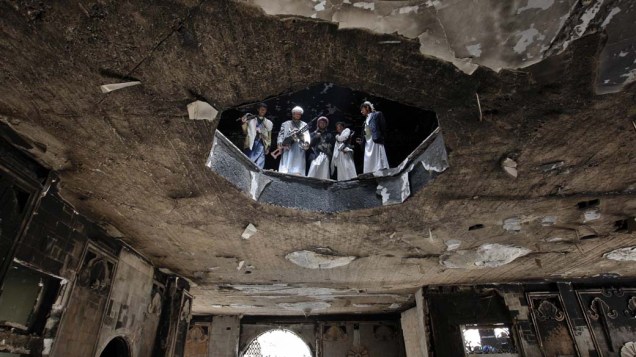 Soldados leais do líder tribal Sheik Sadiq al-Ahmar inspecionam casa destruída em Sanaa, Iêmen