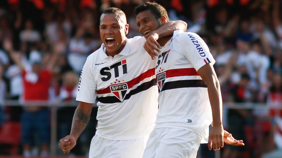 O jogador Luis Fabiano comemora o segundo gol do time do São Paulo, feito pelo jogador Reinaldo (d), durante partida contra o Fluminense