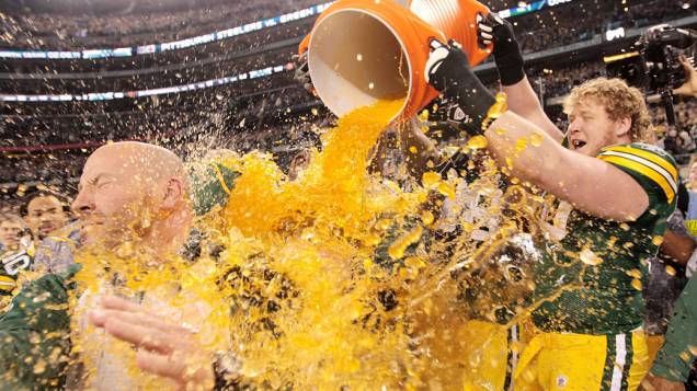 Jogadores do Green Bay Packers comemoram a vitória no Super Bowl XLV dando banho em seu treinador