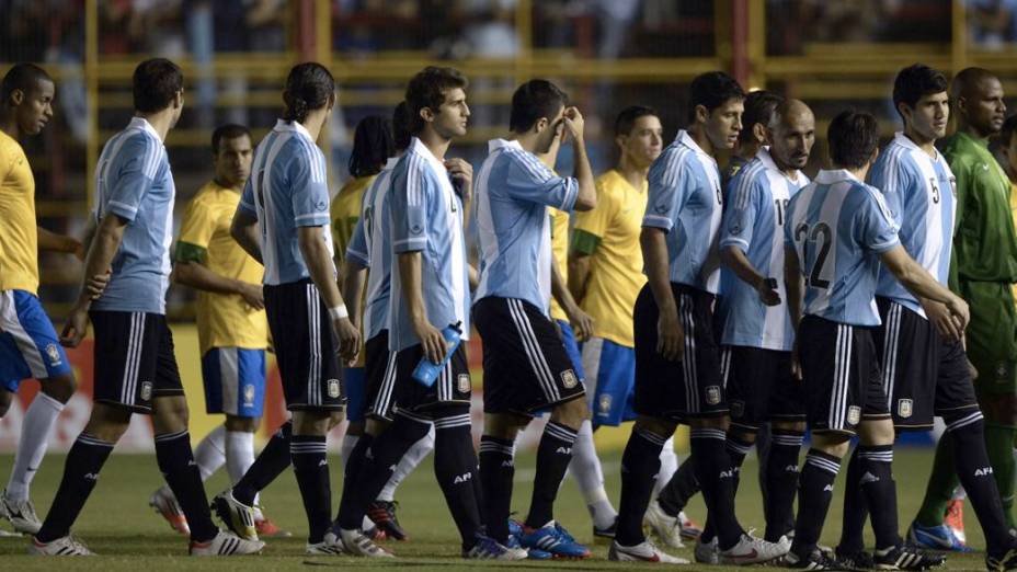 Jogadores de Brasil e Argentina aguardam o início do Superclássico das Américas, em Resistência, depois da falha no sistema de iluminação