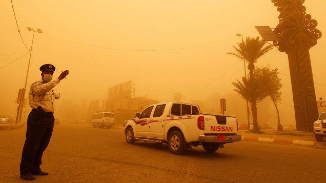 Guarda orienta trânsito em Bagdá, no Iraque, durante uma tempestade de areia que envolveu a cidade nesta quinta-feira