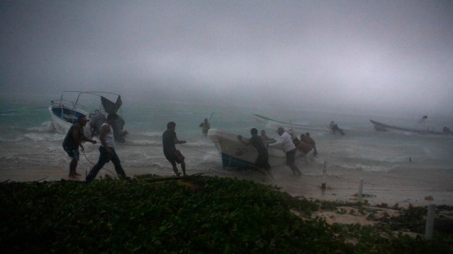 Pescadores tentam segurar seus barcos durante tempestade tropical na cidade de Mahahual, México