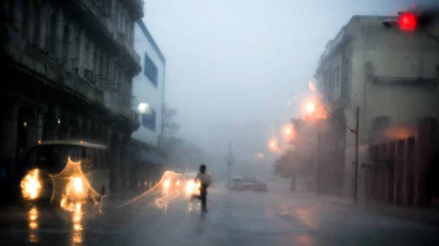 Cubano corre para se proteger da tempestade tropical Paula, que atinge Bahia Honda, próxima à Havana