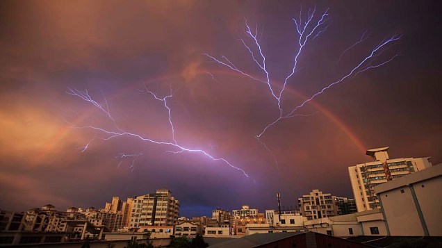 Arco-íris é visto no céu com raios depois de uma tempestade em Haikou, província de Hainan, China