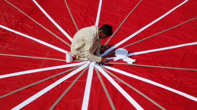 Homem prepara tenda para recepção de casamento na cidade de Lahora, no Paquistão