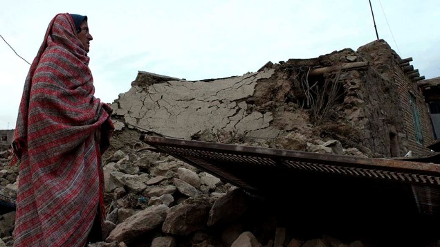 Mulher iraniana observa estragos causados por terremoto, de magnitude 5.5, que matou cinco pessoas em Birjand, Irã