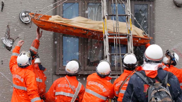 Equipe de resgate retira corpo de casa destruída em Kamaishi, Japão