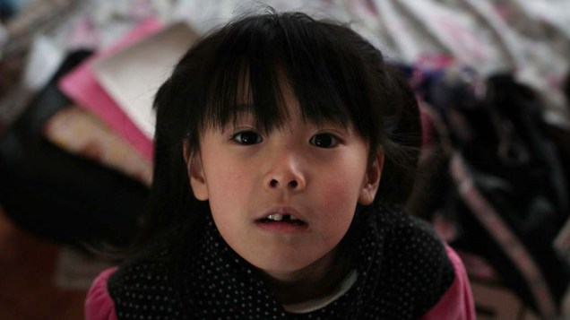Garota em centro de evacuação na cidade de Kensennuma, Japão
