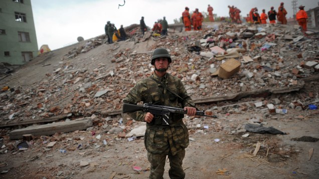Soldado turco durante o resgate de sobreviventes nos escombros de um edifício que desabou após um terremoto em Ercis, Turquia