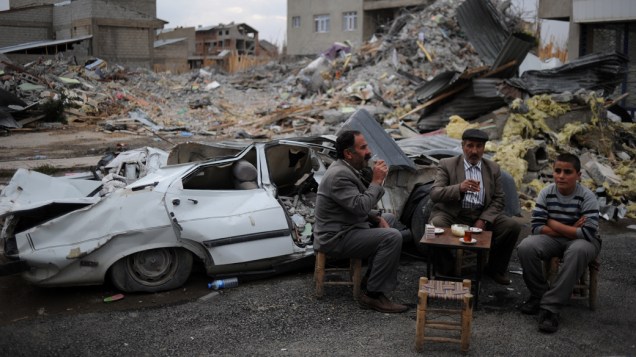 Moradores improvisam mesa nos escombros do terremoto em Ercis, na Turquia