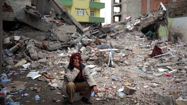 Morador entre escombros em Ercis, na Turquia
