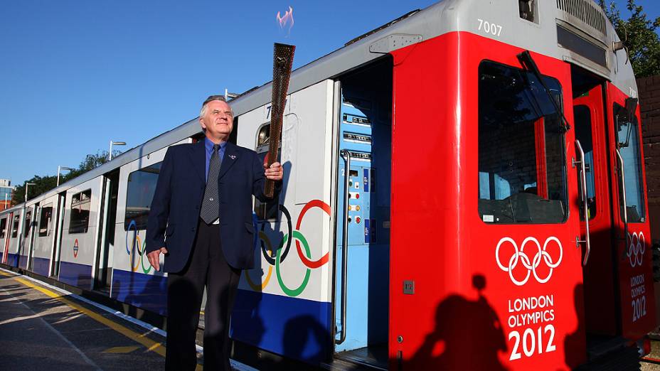 Operador do metrô carrega a tocha em trem decorado com anéis olímpicos