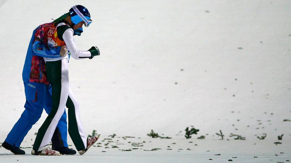 Robert Kranjec, da Eslovênia, é socorrido após cair na prova de salto em esqui