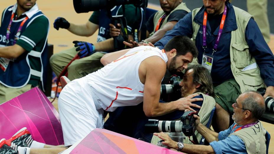 O espanhol Felipe Reyes cai sobre fotógrafos durante partida de basquete