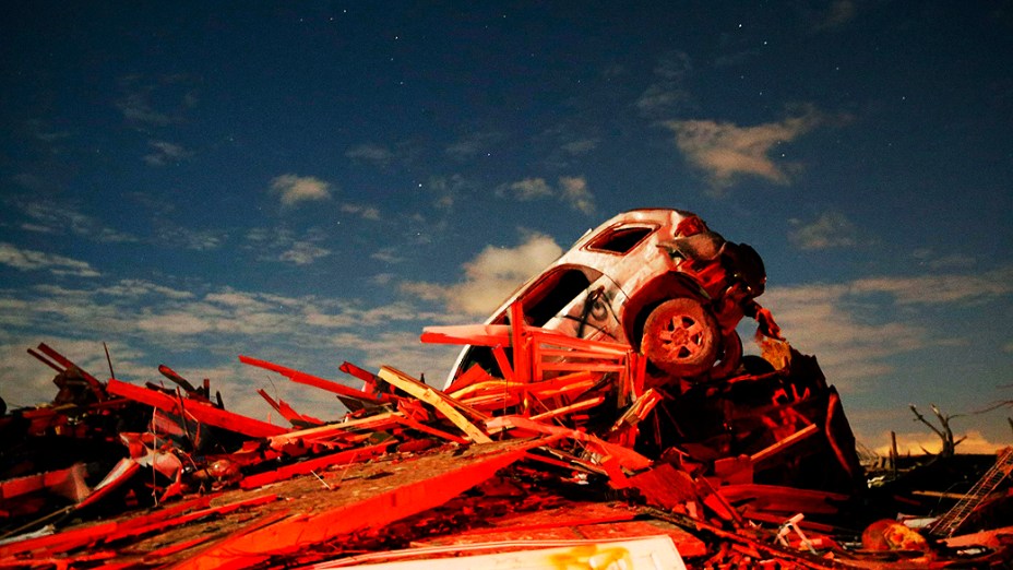 Carro fica em uma pilha de escombros em meio à destruição causada pela passagem de um tornado por Washington, Illinois (EUA)