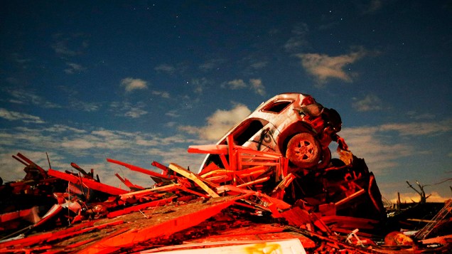 Carro fica em uma pilha de escombros em meio à destruição causada pela passagem de um tornado por Washington, Illinois (EUA)