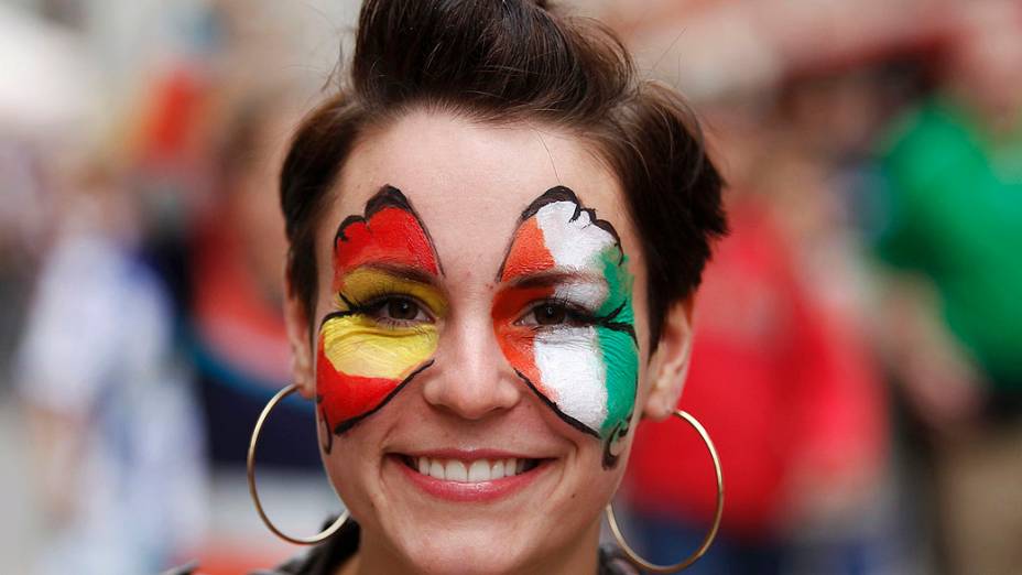 Torcedora com o rosto decorado com asas de borboleta em cores do time irlandês e espanhol, antes da partida de futebol Euro 2012