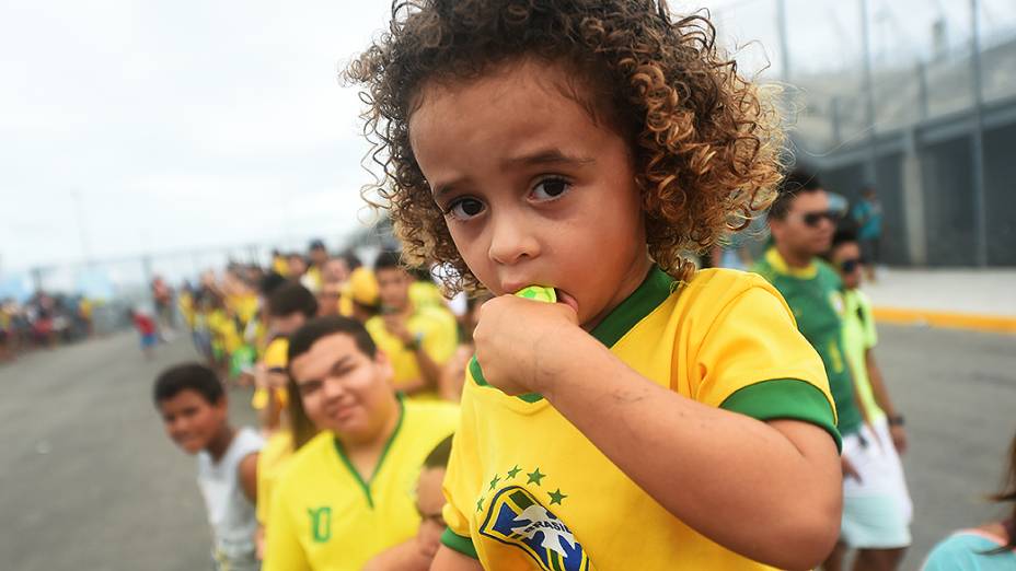 Criança espera pela chegada da seleção brasileira no Castelão, em Fortaleza