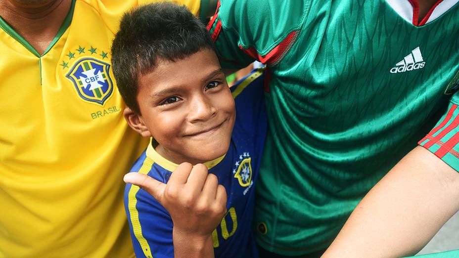 Menino veste a camisa do Brasil para recepcionar a seleção brasileira no Castelão, em Fortaleza