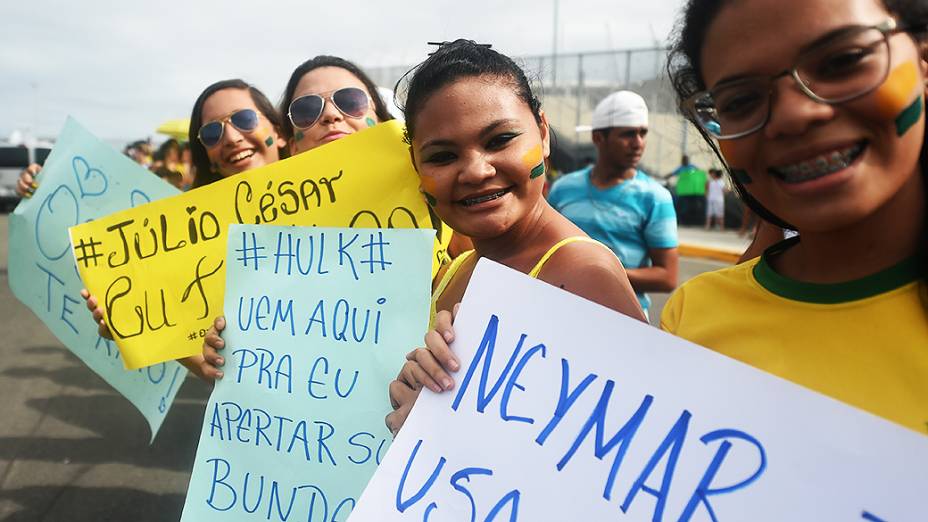 Fãs escrevem cartazes para os jogadores da seleção brasileira no Castelão, em Fortaleza