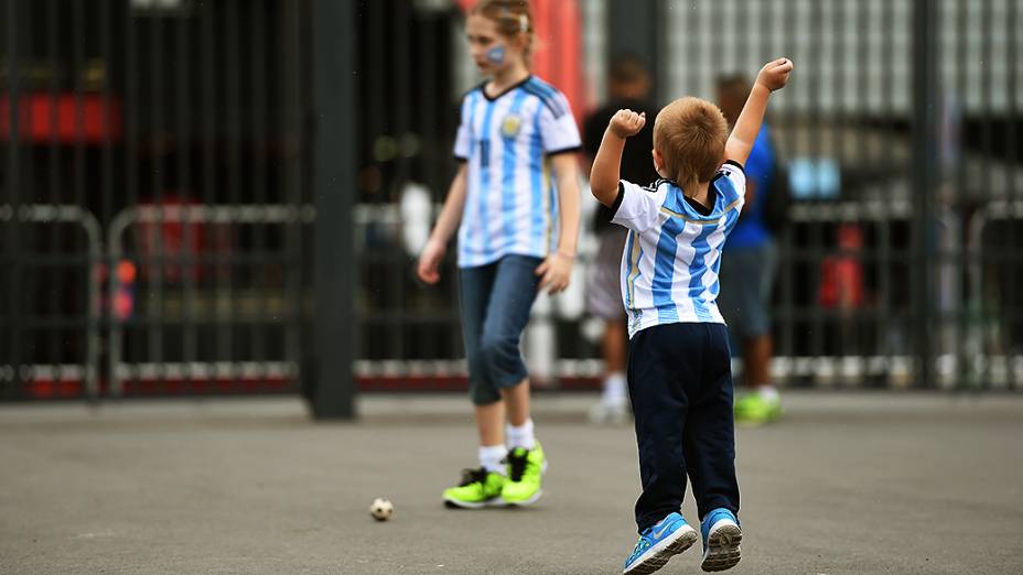 Menino brinca em frente ao Itaquerão antes do jogo entre Argentina e Holanda, em São Paulo