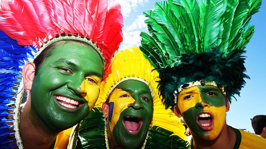 Torcedores pintam o rosto e usam cocar na cabeça antes do jogo contra a Colômbia no Castelão, em Fortaleza