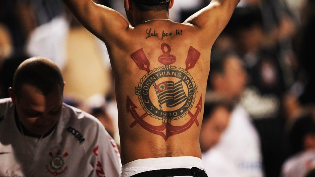 Torcedore do Corinthians mostra tatuagem do time, no estádio do Pacaembu