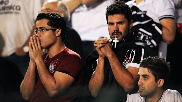Torcedores do Corinthians rezam durante partida da final da Libertadores