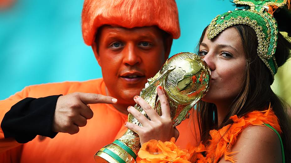 Torcedores beijam a taça da Copa do Mundo de Futebol, durante partida entre Holanda e Costa Rica, na arena Fonte Nova, em Salvador