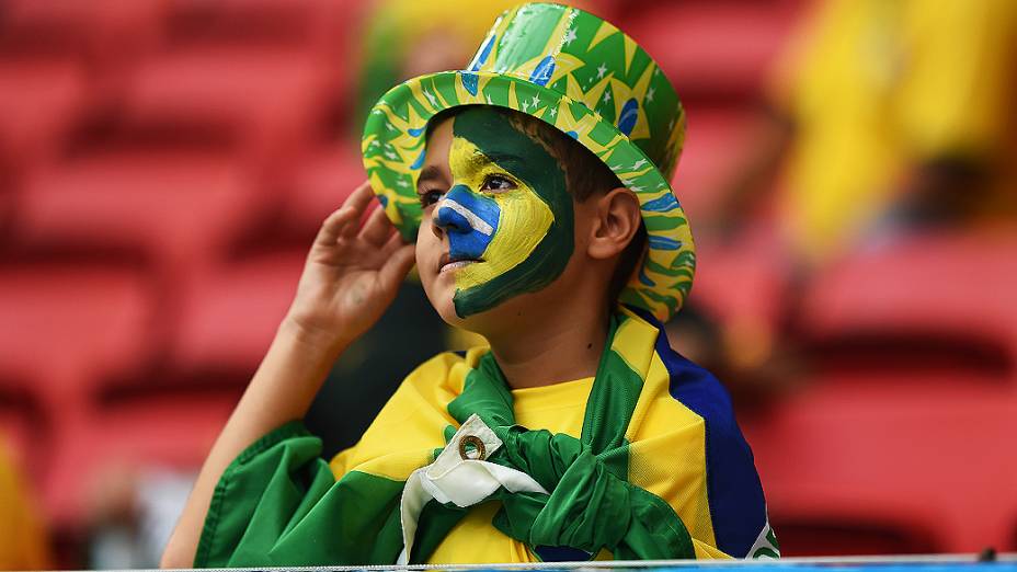 Menino aguarda o início do jogo entre Brasil e Camarões no Mané Garrincha, em Brasília