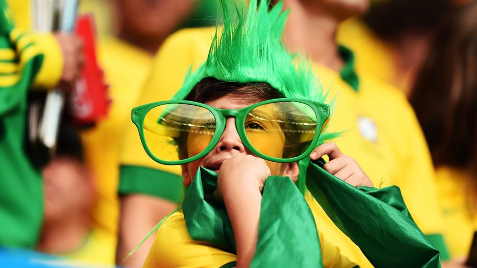 Menino aguarda o início do jogo entre Brasil e Camarões no Mané Garrincha, em Brasília