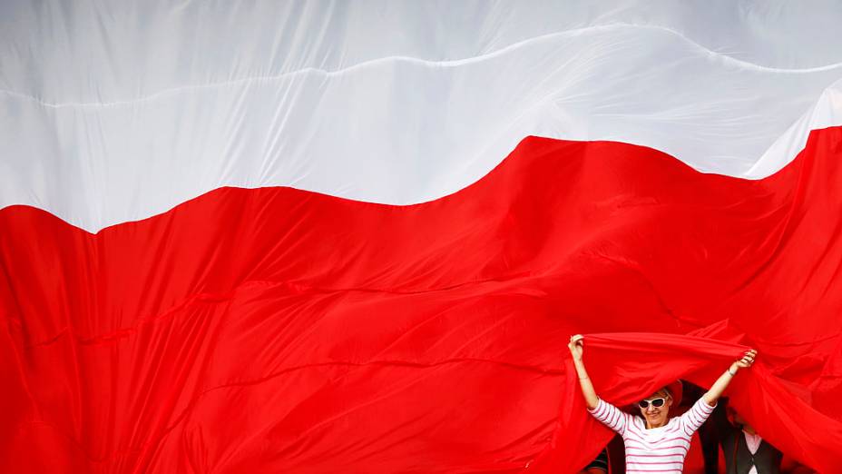 Torcedores da Polônia sob uma grande bandeira durante sessão de treinos da equipe em Varsóvia