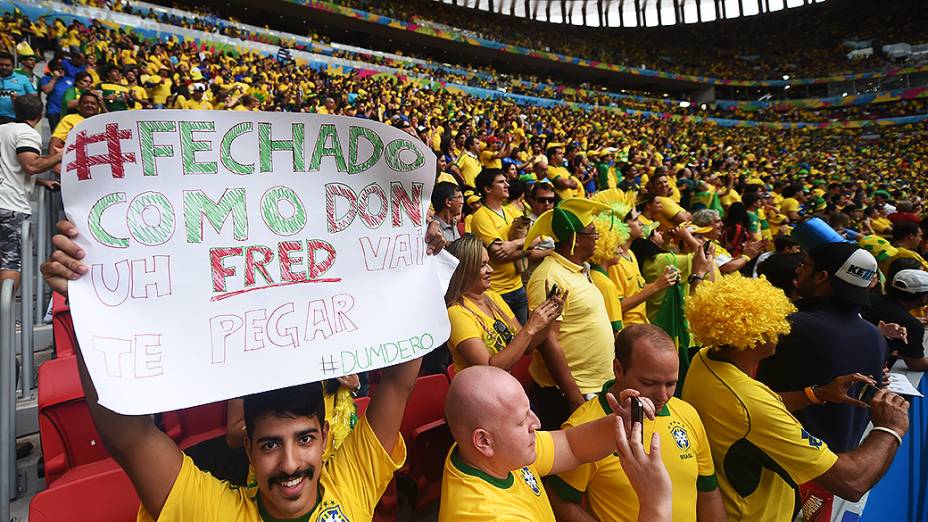 Torcedor brasileiro exibe cartaz no jogo entre Brasil e Camarões no Mané Garrincha, em Brasília