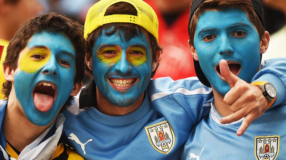 Torcedores do Uruguai pintam o rosto com as cores da bandeira do país, no Itaquerão
